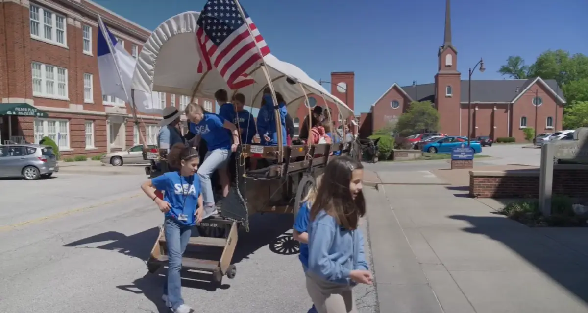 Children on a covered wagon tour at the museum